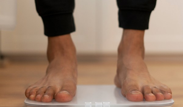 Person measuring weight, overcoming the fear of the scale.